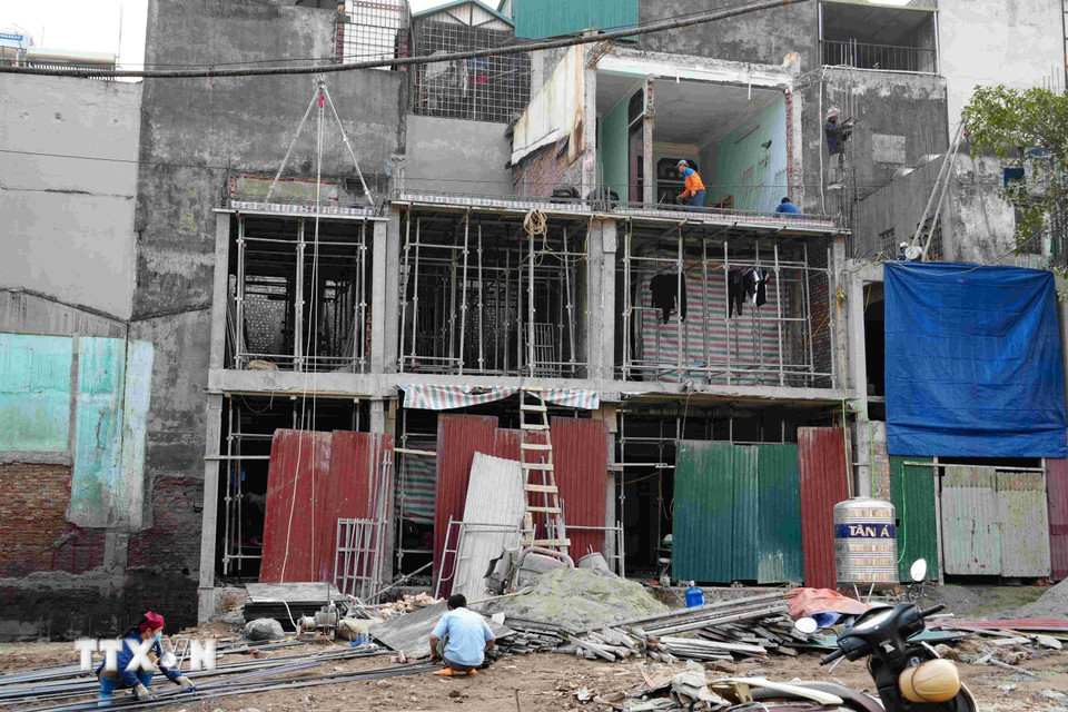 Tận dụng vị trí đắc địa vừa có được, nhiều chủ hộ gấp rút thay đổi kết cấu, nâng tầng và mở rộng không gian sử dụng. (Ảnh: Vũ Quang/TTXVN)