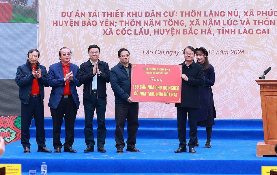 Thủ tướng Phạm Minh Chính và các nhà tài trợ trao tặng biểu trưng hỗ trợ xóa nhà tạm, nhà dột nát cho lãnh đạo địa phương. (Ảnh: Dương Giang/TTXVN)