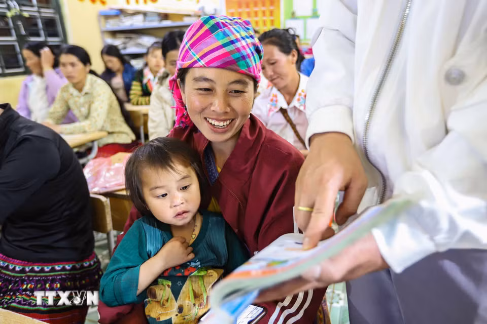 Học sinh Hạng Thị Cha đọc theo hướng dẫn của thầy giáo trên sách giáo khoa tiếng việt lớp 1. (Ảnh: Trọng Đạt/TTXVN)
