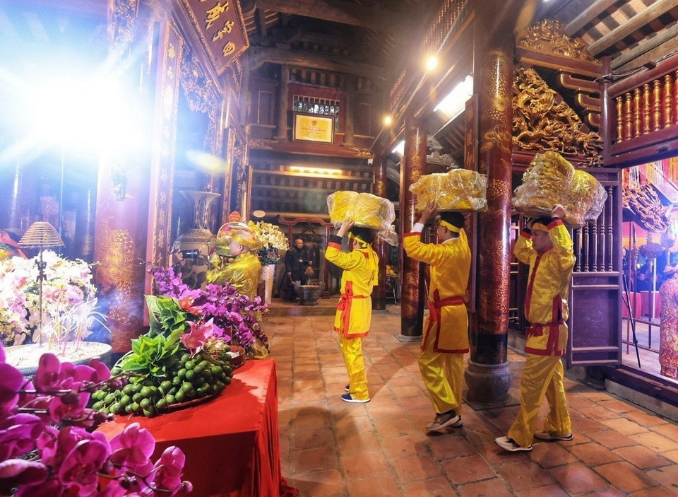 Dâng lễ phẩm lộc hoa tre vào đền. (Ảnh: Tuấn Anh/TTXVN)