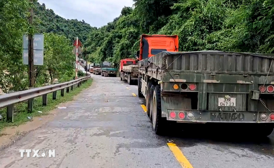Hàng trăm xe tải chở hàng hóa, nhu yếu phẩm nối đuôi nhau hàng kilomet, buộc phải dừng lại giữa đường, chờ thông tuyến. (Ảnh: TTXVN phát)