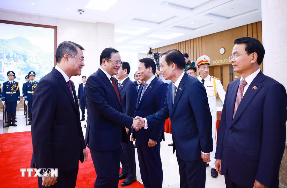Thủ tướng Lê Minh Hưng giới thiệu với Thủ tướng Lào Sonexay Siphandone thành viên đoàn Việt Nam tham dự lễ đón. (Ảnh: Dương Giang/TTXVN) ​