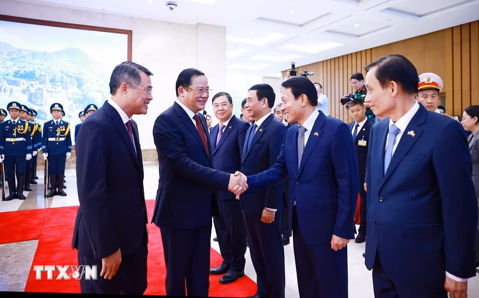 Thủ tướng Lê Minh Hưng giới thiệu với Thủ tướng Lào Sonexay Siphandone thành viên đoàn Việt Nam tham dự lễ đón. (Ảnh: Dương Giang/TTXVN)