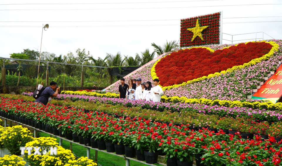 Du khách đến tham quan, chụp ảnh với “Trái tim” khổng lồ tại Tổ hợp tác sản xuất và cung ứng hoa, kiểng Tân An (đường Phạm Hữu Lầu, khóm Tân An, phường Sa Đéc). (Ảnh: Nhựt An/TTXVN)