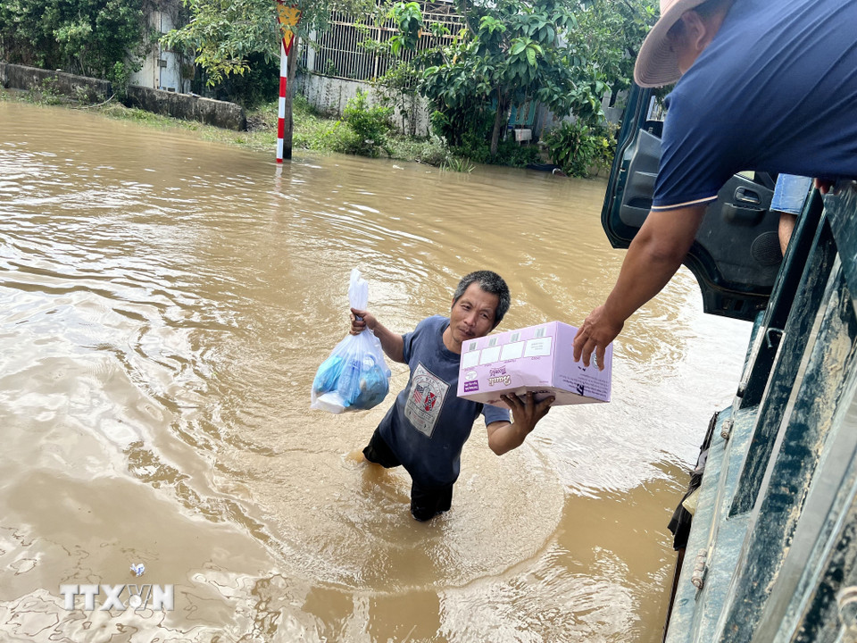 Thanh niên dùng xe ben đi phát cơm, tiếp tế người dân Hàm Thắng. (Ảnh: Hồng Hiếu/TTXVN)