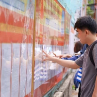 Người dân nghiên cứu danh sách các ứng cử viên được niêm yết tại các điểm bầu cử. (Ảnh: Khoa Chương/TTXVN)