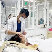 Bác sỹ Bệnh viện Quân y 175, Thành phố Hồ Chí Minh điều trị cho bệnh nhân sốt xuất huyết nặng. (Ảnh: TTXVN/Vietnam+)