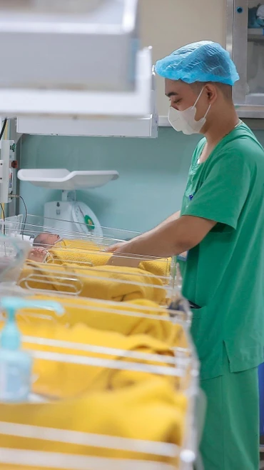 Nhân viên y tế chăm sóc cho trẻ sơ sinh. (Ảnh: Minh Quyết/TTXVN)