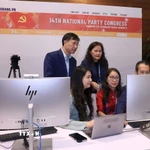 Phóng viên, biên tập viên của TTXVN tác nghiệp tại Trung tâm báo chí của Đại hội. (Ảnh: TTXVN phát)