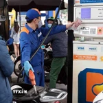 Khách hàng mua bán xăng, dầu tại một điểm kinh doanh xăng dầu của Petrolimex trên địa bàn Hà Nội. (Ảnh: Trần Việt/TTXVN)