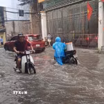 Không ít xe máy bị chết máy khi đi qua vùng ngập. (Ảnh: Nguyễn Thắng/TTXVN)