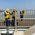 Công nhân đường sắt nỗ lực khắc phục sự cố cầu Ghềnh sau khi xảy ra tai nạn khiến tuyến đường sắt Bắc-Nam gián đoạn. (Ảnh: Sỹ Tuyên/TTXVN)