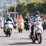 Người dân sử dụng khẩu trang, áo chống nắng giúp tránh nóng bức khi tham gia giao thông. (Ảnh: Lê Đông/TTXVN)