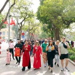 Du khách trong nước và quốc tế thảnh thơi du xuân bên hồ Hoàn Kiếm. (Ảnh: Phạm Kiên/TTXVN)