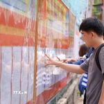 Sinh viên Trường Đại học Sư phạm Kỹ thuật (Đại học Đà Nẵng) nghiên cứu danh sách các ứng cử viên được niêm yết tại nhà trường. (Ảnh: Khoa Chương/TTXVN)