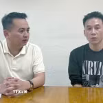 Đối tượng Lê Long Anh (phải) tại cơ quan công an. (Ảnh: TTXVN phát)