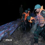 Các lực lượng đắp đê chống tràn, bảo đảm an toàn tuyến đê hữu Cầu. (Ảnh: Dương Giang/TTXVN)