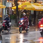 Người dân phường Mỹ Tho tham gia giao thông dưới cơn mưa chiều 15/5. (Ảnh: Hồng Thái/TTXVN)