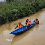 Lực lượng chức năng đưa người dân bị mắc kẹt do ngập sâu tại phường 3 Bảo Lộc (Lâm Đồng) đến nơi an toàn. (Ảnh: TTXVN phát)