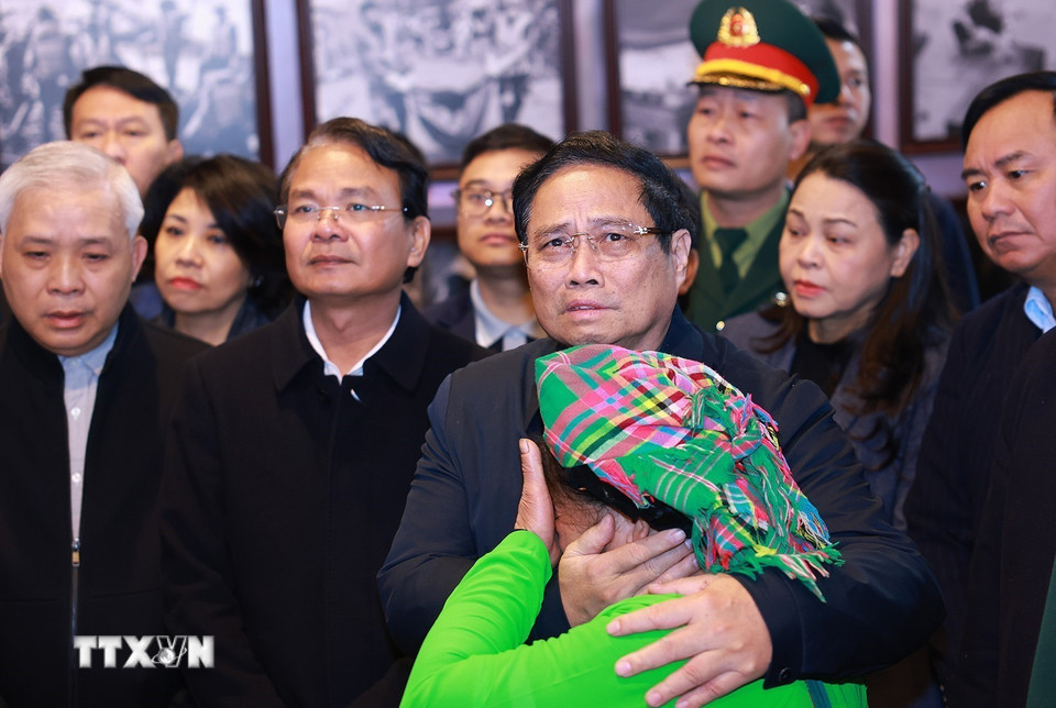 Thủ tướng Phạm Minh Chính tham quan trưng bày ảnh, hiện vật và gặp người dân có người thân thiệt mạng trong trận lũ quét tại Nhà văn hóa thôn Làng Nủ. (Ảnh: Dương Giang/TTXVN)