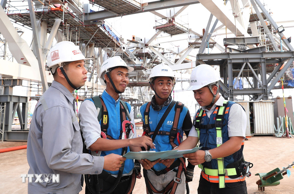 Các kỹ sư, công nhân trao đổi công việc trên công trường. (Ảnh: Quốc Khánh/TTXVN)