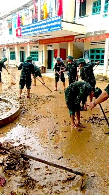 Cán bộ, chiến sỹ Cục Hậu cần - Kỹ thuật Quân khu 5 hỗ trợ một trong tiểu học trên địa bàn xã Nông Sơn dọn bùn non sau khi nước rút. (Ảnh: PV/Vietnam+)