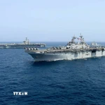 Tàu sân bay USS Abraham Lincoln (phía sau) của hải quân Mỹ di chuyển trên Biển Arab. (Ảnh minh họa. AP/TTXVN)
