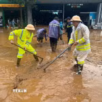 Lực lượng Cảnh sát giao thông, Công an Sơn La nạo bùn, khơi thông cống rãnh do mưa lớn kéo dài xảy ra tại xã Mường La. (Ảnh: TTXVN phát)