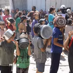 Trẻ em xếp hàng nhận thức ăn cứu trợ tại trại tị nạn Jabalia ở Dải Gaza. (Ảnh: THX/TTXVN)