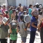 Trẻ em xếp hàng nhận thức ăn cứu trợ tại trại tị nạn Jabalia ở Dải Gaza. (Ảnh: THX/TTXVN)