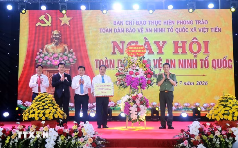 Đại tướng Lương Tam Quang, Ủy viên Bộ Chính trị, Bộ trưởng Bộ Công an tặng hoa chúc mừng xã Việt Tiến, tỉnh Hưng Yên. (Ảnh: Đinh Văn Nhiều/TTXVN)