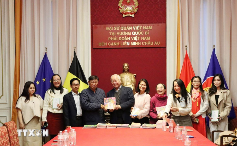 Ông Đỗ Phước Trung, Phó Giám đốc Sở Văn hóa và Thể thao Thành phố Hồ Chí Minh, trao tặng sách cho ông Huỳnh Công Mỹ, Chủ tịch Tổng hội người Việt Nam tại Vương quốc Bỉ. (Ảnh: Duy Tùng/TTXVN)