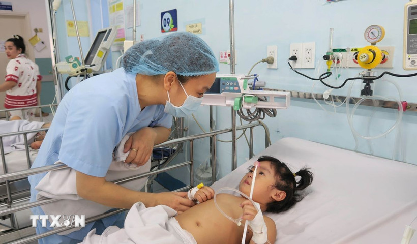 Nhân viên y tế Bệnh viện Nhi đồng 1 Thành phố Hồ Chí Minh chăm sóc bệnh nhi mắc tay chân miệng. (Ảnh: Đinh Hằng/TTXVN)
