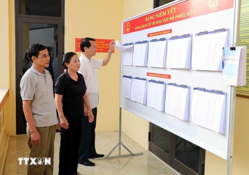 Người dân theo dõi danh sách cử tri tại Khu vực bỏ phiếu số 1, xã Gia Viễn, tỉnh Ninh Bình. (Ảnh: Thùy Dung/TTXVN)