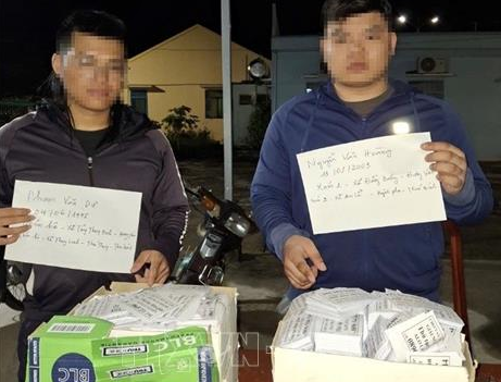 Hai đối tượng có hành vi phát tờ rơi cho vay trả góp bị lực lượng Công an xã Vĩnh Hòa bắt quả tang. (Ảnh: TTXVN phát)