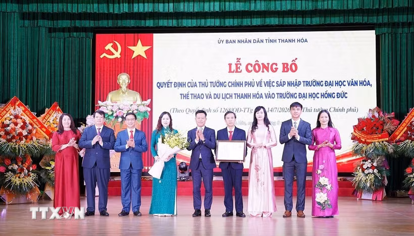 Thứ trưởng Bộ GD & ĐT Lê Quân trao Quyết định của Thủ tướng Chính phủ về sáp nhập Trường Đại học Văn hóa, Thể thao và Du lịch Thanh Hóa vào Trường Đại học Hồng Đức. (Ảnh Khiếu Tư/TTXVN)