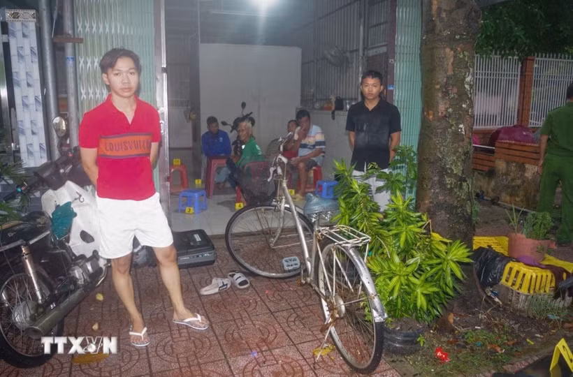 Các đối tượng liên quan vụ "Cố ý gây thương tích dẫn đến chết người" tại phường Khánh Hậu, tỉnh Tây Ninh được Cơ quan Cảnh sát điều tra Công an tỉnh Tây Ninh đưa đến hiện trường để phục vụ công tác điều tra. (Ảnh: TTXVN phát)
