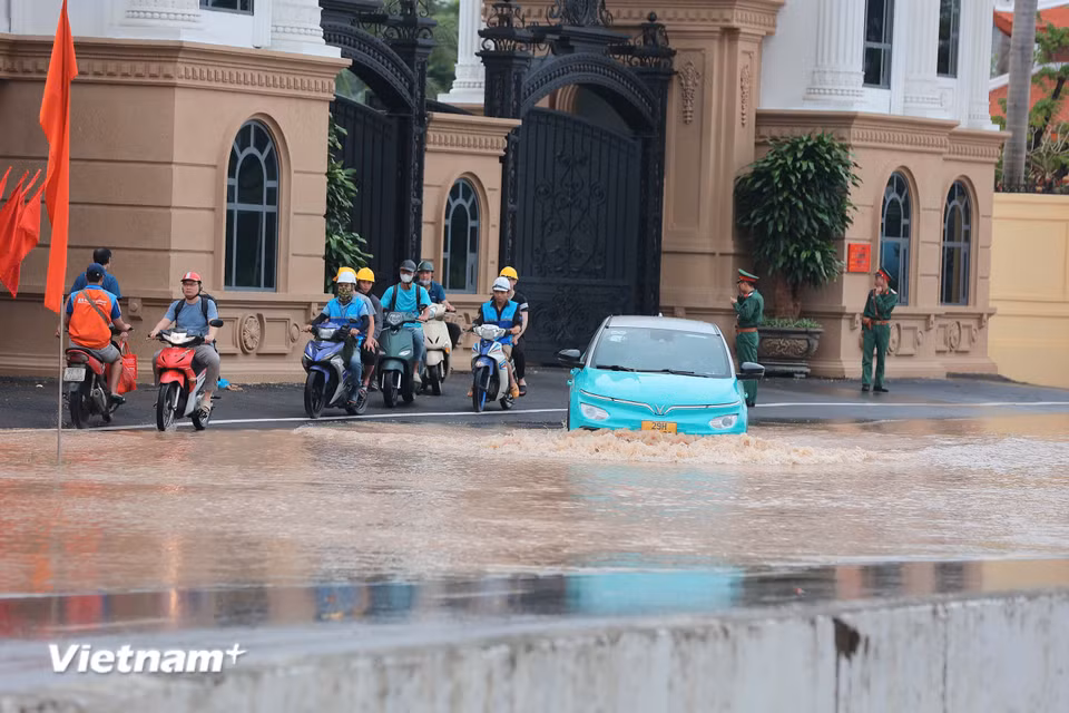Đơn vị đã mở lối, hỗ trợ người dân đi qua khu vực ngập sâu. (Ảnh: Hoài Nam/Vietnam+)