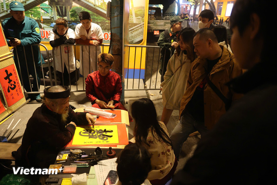 Một số hoạt động văn hóa đặc sắc như viết chữ xin lời chúc cho năm mới vẫn diễn ra và được nhiều người quan tâm. (Ảnh: Hoài Nam/Vietnam+)