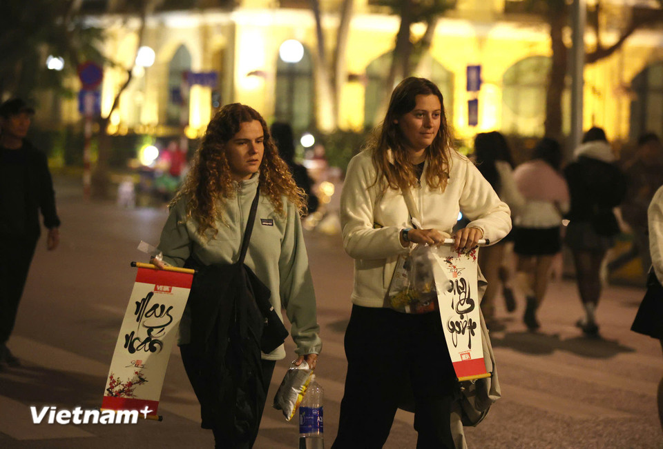 Hai khách du lịch trẻ tuổi cũng xin chữ. (Ảnh: Hoài Nam/Vietnam+)