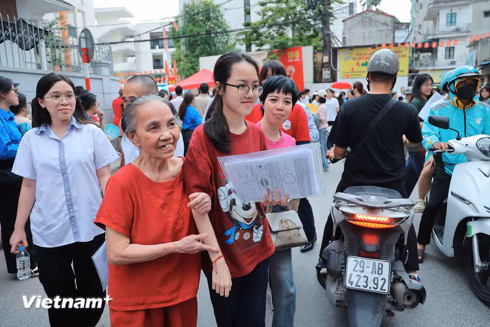 Thấy sỹ tử yên tâm, gia đình cũng thở phào nhẹ nhõm để hòa chung niềm vui với con, cháu. (Ảnh: Hoài Nam/Vietnam+)