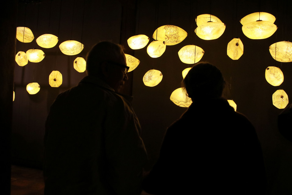 "Chạm" - tác phẩm mang tạo hình những hạt thóc, trên đó khắc họa những hình ảnh biểu tượng văn hóa nổi bật trong không gian Thăng Long xưa. (Ảnh: Minh Anh/Vietnam+)