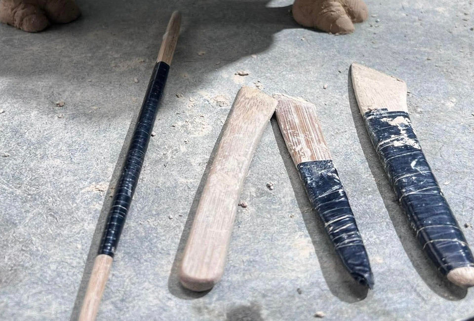 Các dụng cụ được anh Quyền sử dụng trong quá trình tạo hình đều rất đơn giản, chủ yếu là những con dao được làm bằng tre, với đầu nhỏ, nhọn để tạo hình dễ hơn, mềm mại hơn. (Ảnh: Hương Ly/Vietnam+)
