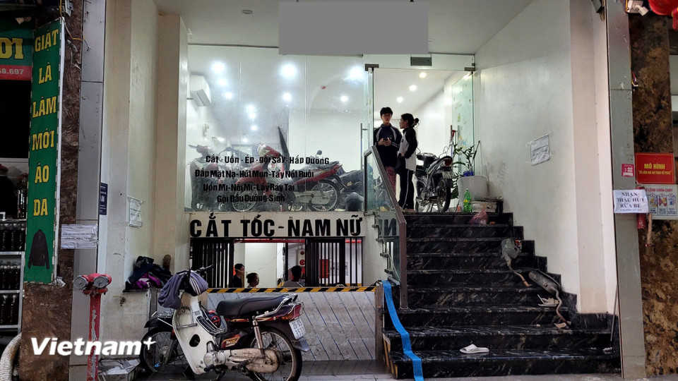 Một tiệm cắt tóc trên đường Phú Đô phải di rời loạt xe máy lên cao, kết hợp chặn cửa hầm để ngăn nước lụt tràn vào. (Ảnh: Minh Anh/Vietnam+)
