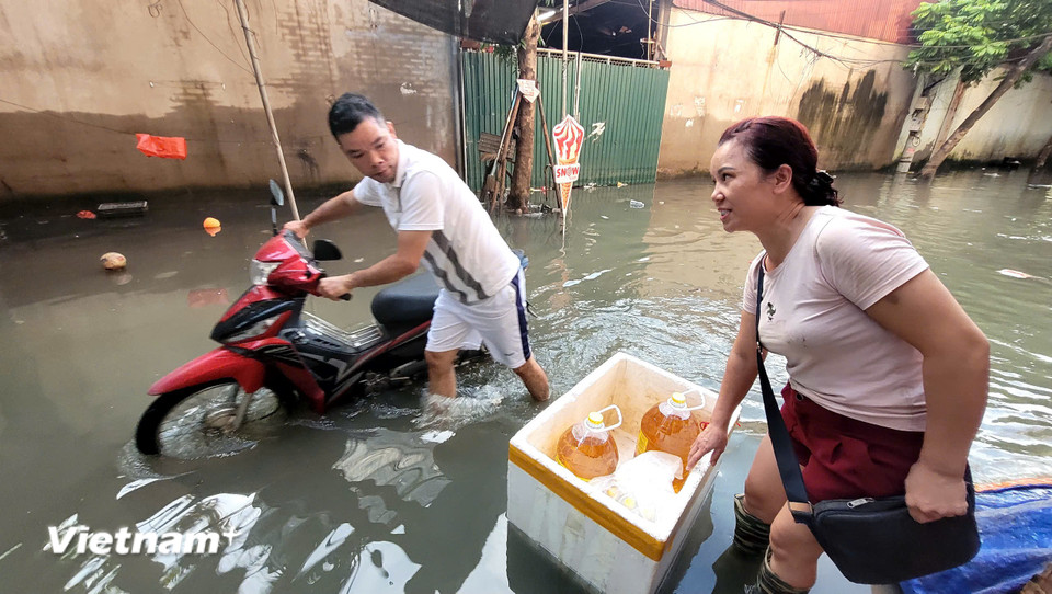 Ngập lụt khiến người dân khu vực này đảo lộn, hàng loạt xe chết máy. (Ảnh: Minh Anh/Vietnam+)