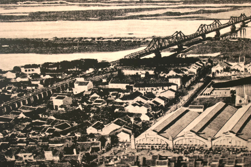 Chợ Đồng Xuân bên cầu Long Biên (bấy giờ là cầu Paul Doumer lấy theo tên của Toàn quyền Đông Dương) giữa thế kỷ 20, khi đó chợ đã có 5 dãy chợ hoàn chỉnh. (Ảnh tư liệu thuộc bộ sưu tập cá nhân)