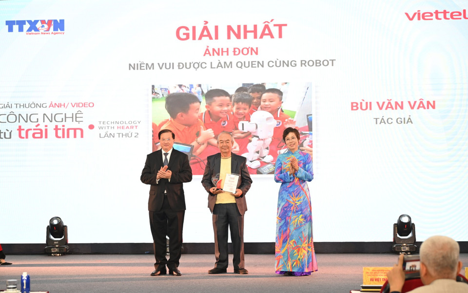 Tác giả lớn tuổi Bùi Văn Vân nói không ngờ được giải Nhất với Ảnh đơn "Niềm vui được làm quen cùng robot," chia sẻ chụp được khoảnh khắc trong ảnh và góp mặt tại giải thưởng là sự may mắn và niềm vinh dự của mình. (Ảnh: Minh Anh/Vietnam+)
