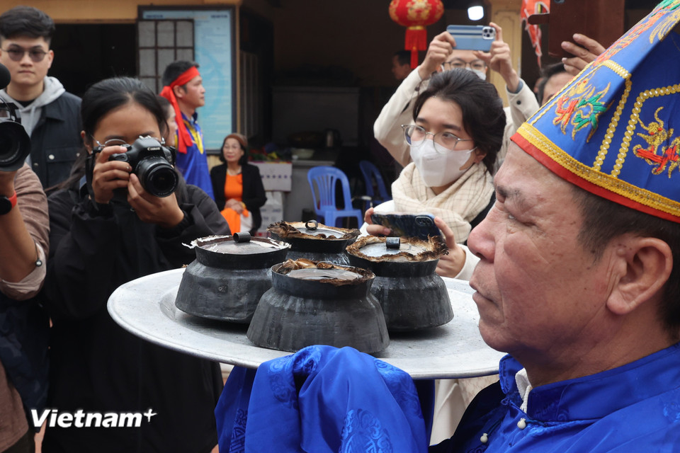 Tìm được đủ 4 nồi của 4 đội, chủ tế và ban giám khảo đem cơm vào đình dâng lên thánh, sau đó mới bắt đầu chấm điểm. (Ảnh: Minh Anh/Vietnam+)