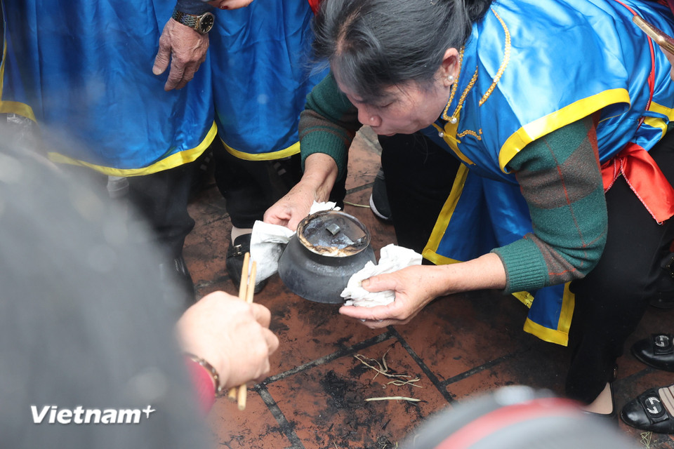 Để đảm bảo cơm vẫn trắng, sạch, các đội thi đậy dưới nắp một lớp vải ẩm. (Ảnh: Minh Anh/Vietnam+)