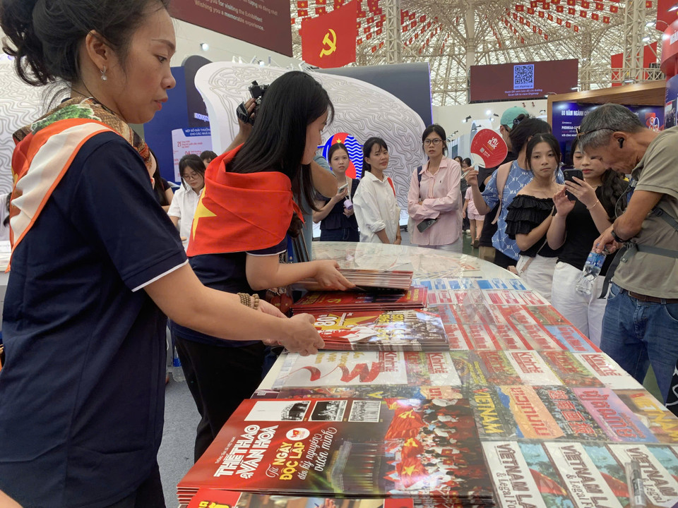 Đại diện gian trưng bày của Thông tấn xã Việt Nam cho biết phải liên tục bổ sung sản phẩm để kịp phân phát cho du khách. (Ảnh: Minh Anh/Vietnam+)